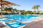 Piscina cu sezlonguri si umbrele de soare